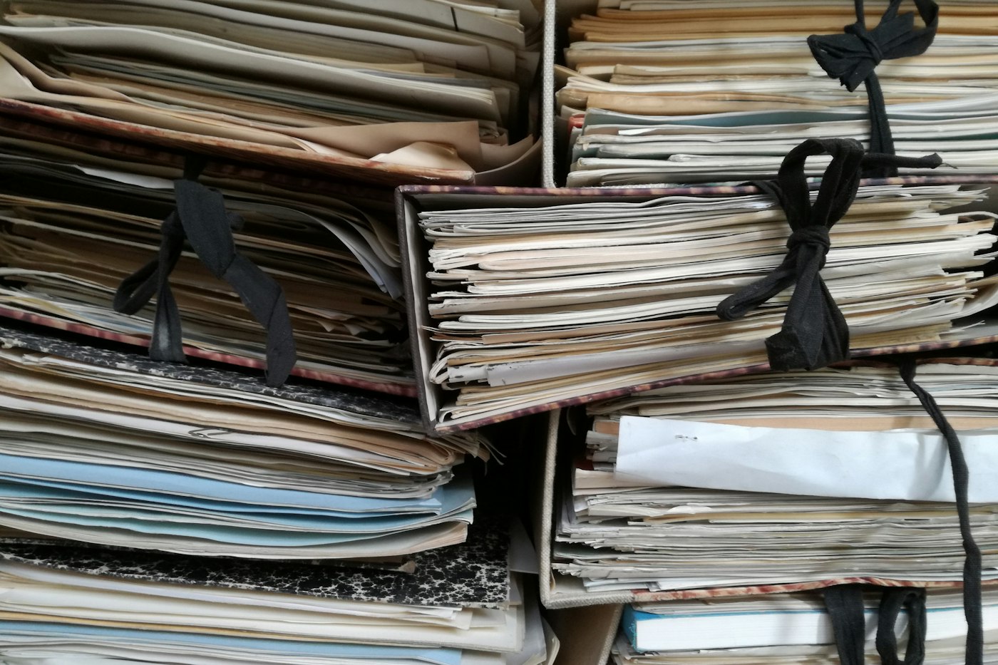 Stacks of old paper files tied with string