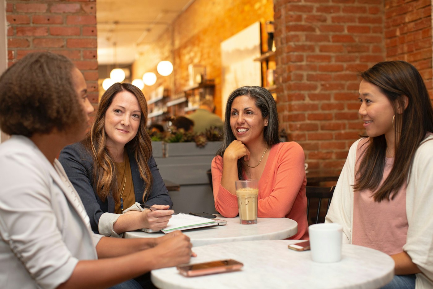 Four women talking around a café table